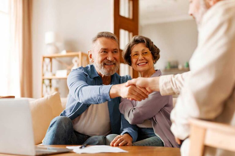 A couple reviews a life insurance denial letter and medical records at a kitchen table.