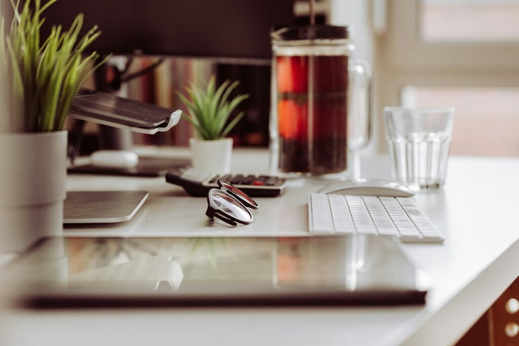 Home office with a laptop, monitors, filing cabinet, receipts, and an insurance policy on the desk
